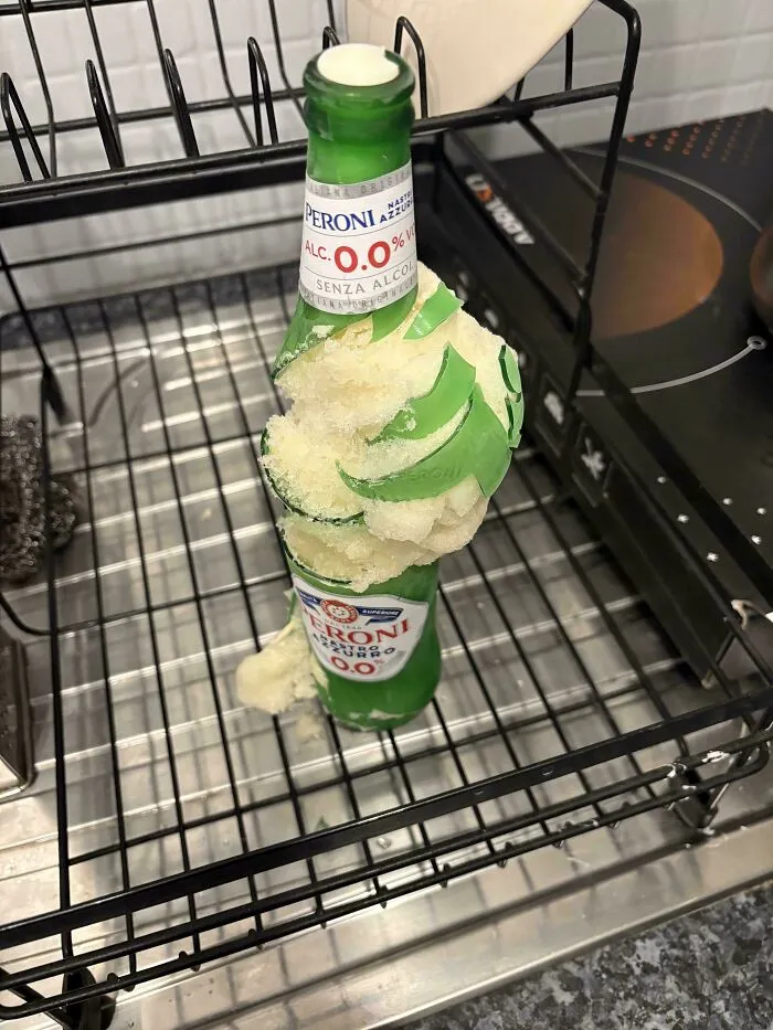 Botella congelada rota con espuma en lavavajillas, un ejemplo de personas que olvidaron algo importante y documentaron las consecuencias.