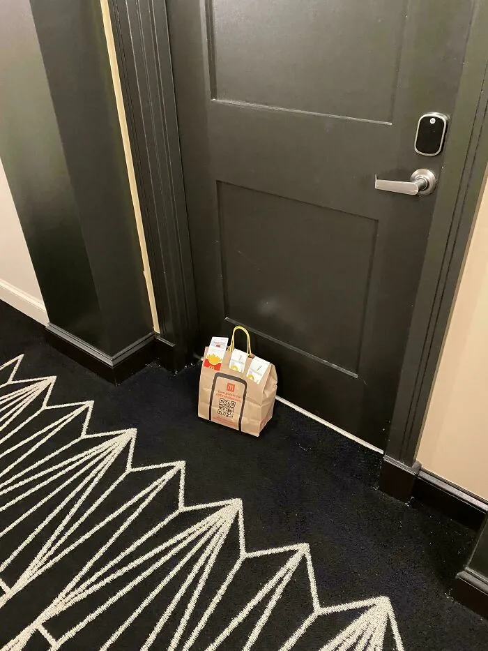 Paper bag with food delivery left outside a closed door, illustrating people forgetting and funny unfortunate situations.