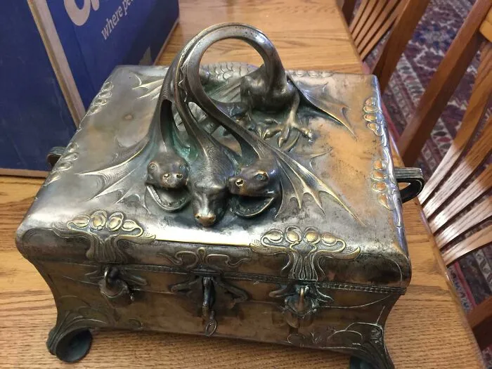 Antique ornate metal box with intricate animal-shaped handles, showcasing beautiful old collectible craftsmanship and design.