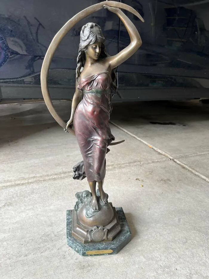 Bronze statue of a woman holding a crescent moon on a decorative base, a beautiful old collectible item.