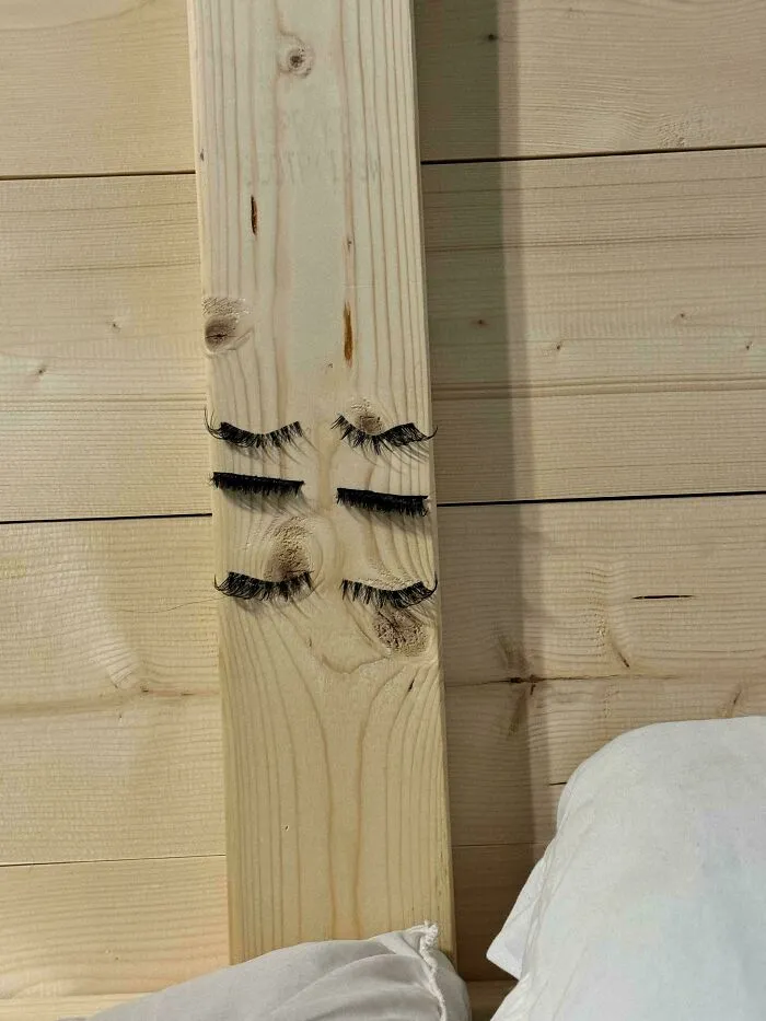False eyelashes stuck on wooden beam resembling closed eyes in a funny unfortunate situation of forgetting something.