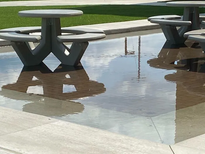 School Does Some Renovations. New Outside Area Has The Tables In A Lower Section Surrounded By A Step Up Of Pavement. Guess What Happened When It Rained