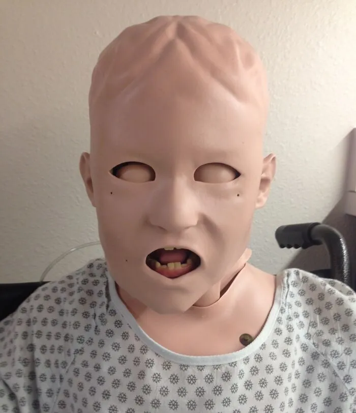 Maniquí médico con rostro deformado y expresiones aterradoras, usado para entrenamiento en fotos médicas del cuerpo humano.