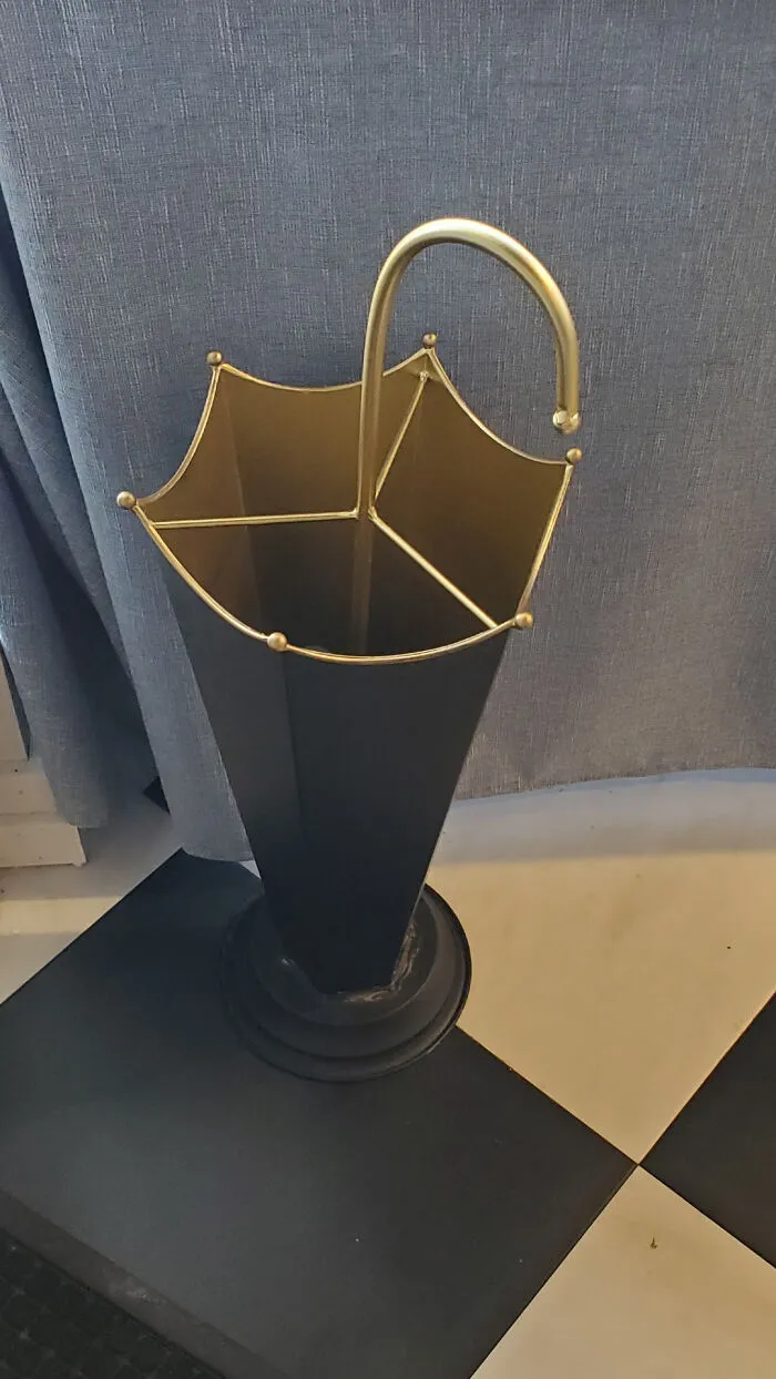Umbrella-shaped black metal stand with golden frame details, showcasing smart and cool designer innovation in home accessories.