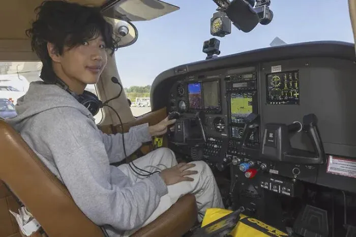 Joven sentado en cabina de avión pequeño mostrando cosas interesantes que la gente comparte sobre aviación.