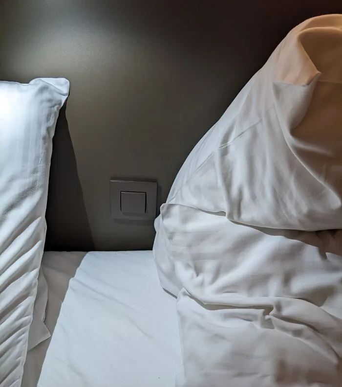 El interruptor de la luz de la habitación del hotel está oculto tras las almohadas, por lo que te despiertas inexplicablemente en mitad de la noche.