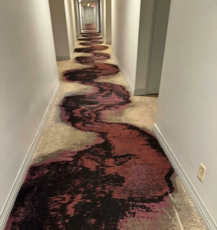 Pasillo de hotel con alfombra desgastada y rota mostrando uno de los sorprendentes fallos en alojamientos que impactan a huéspedes.