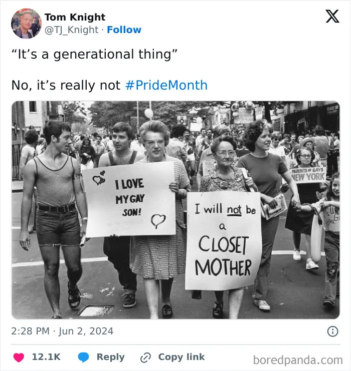 Black and white photo of people holding supportive signs at a pride march, promoting positivity and acceptance.