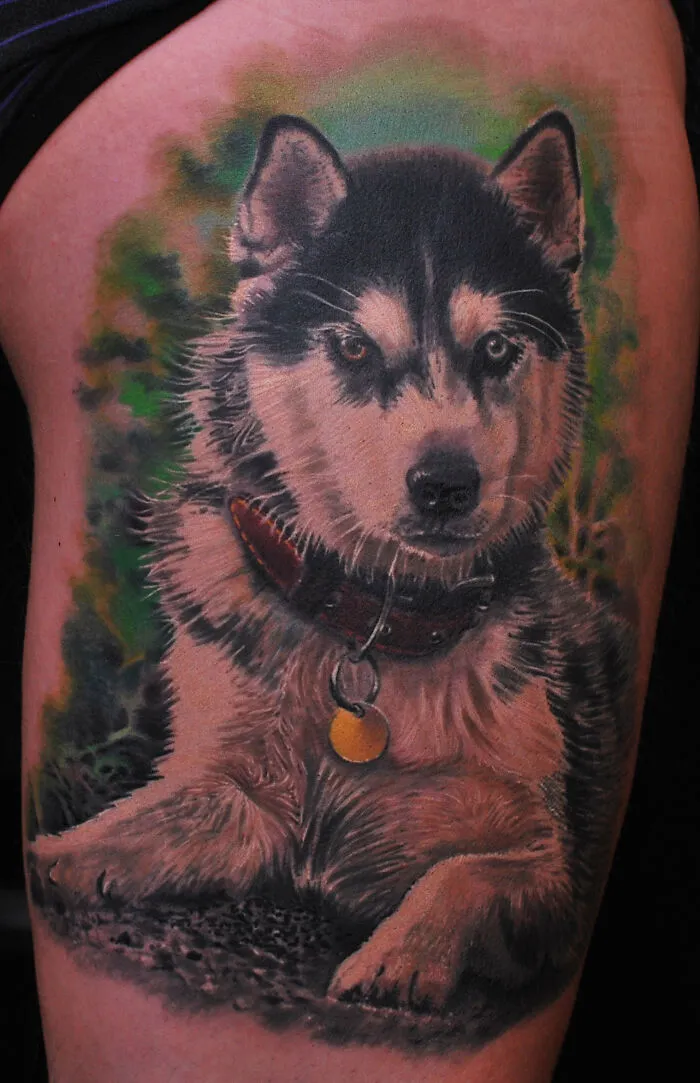 Realistic dog tattoo on arm with detailed fur and collar, one of the best tattoos loved by many people.