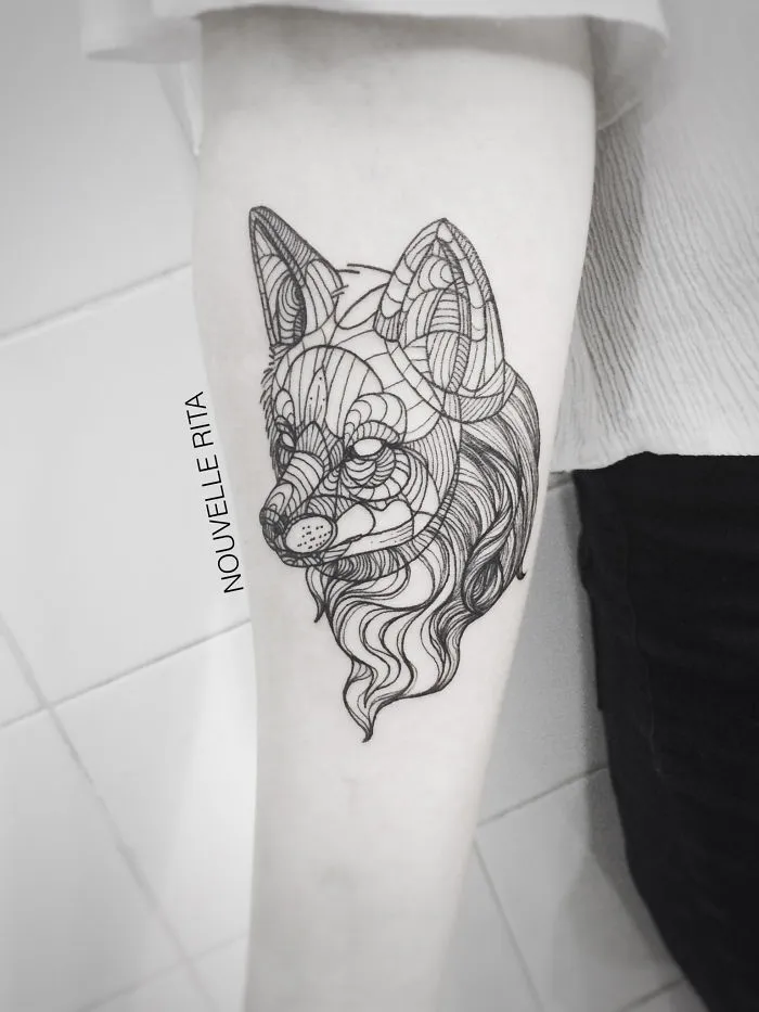 Intricate black ink tattoo of a stylized fox head with detailed line work on a person's forearm, showcasing best tattoos.