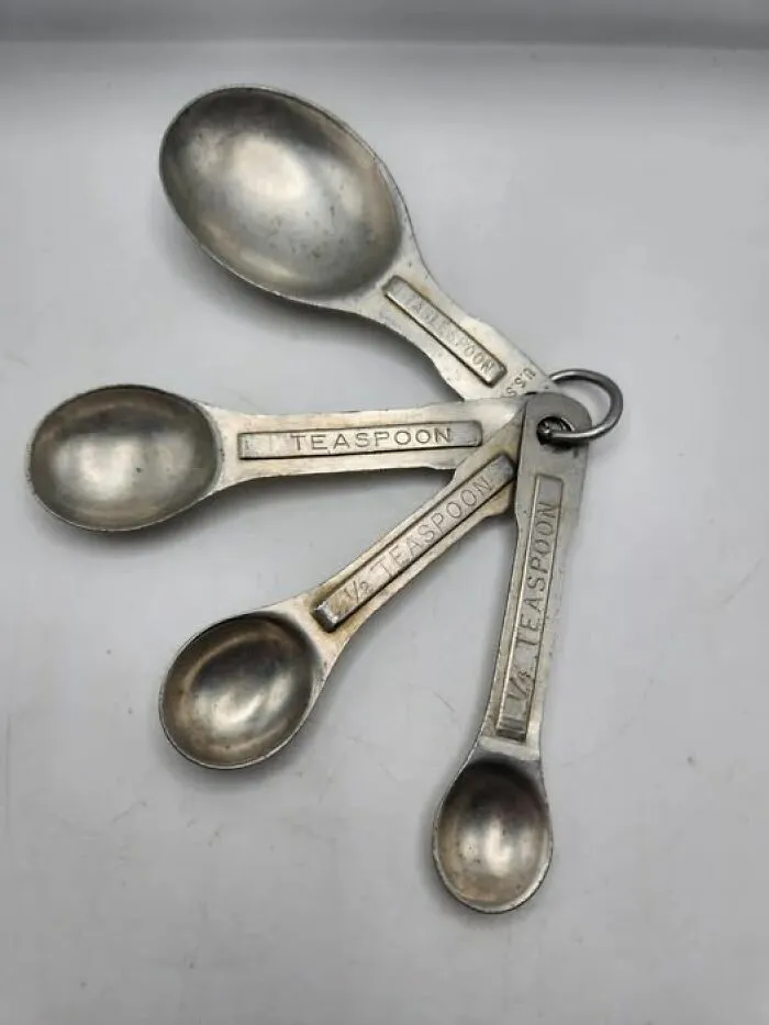 Set of vintage metal measuring spoons on a ring showing various teaspoon sizes, a weird and wonderful vintage item.