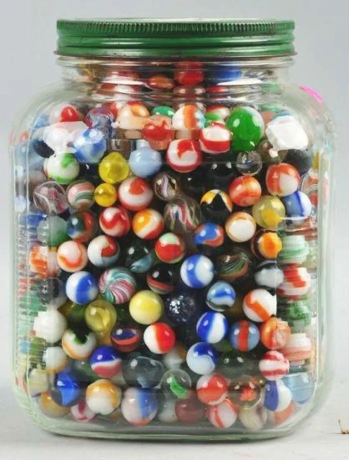 Glass jar filled with colorful vintage marbles, showcasing classic nostalgic vintage things collectible and decorative.