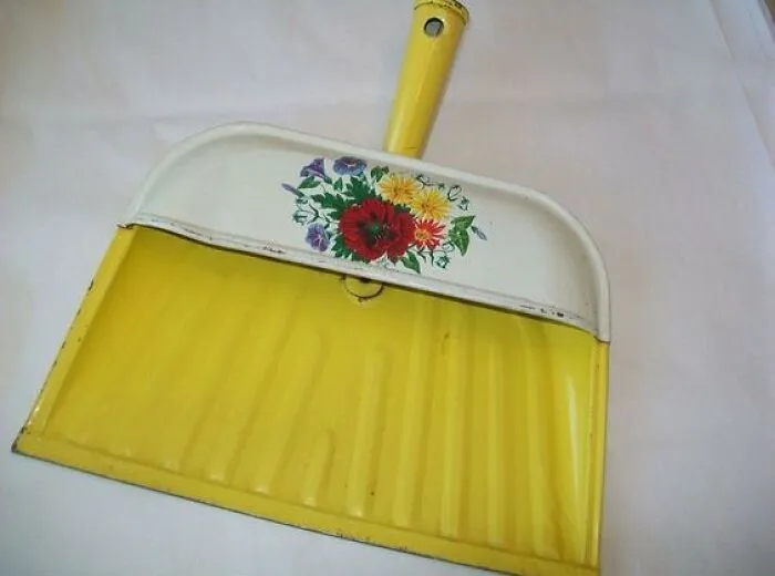 Vintage dustpan with yellow base and floral design, showcasing unique and colorful retro style from past decades