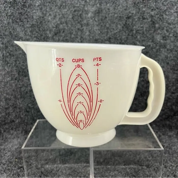 Vintage cream-colored measuring cup with red markings for quarts, cups, and pints, showcasing unique vintage kitchenware.