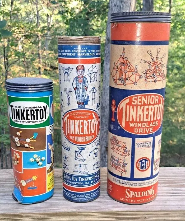 Vintage Tinkertoy construction sets in original tubes showcasing classic design and packaging from past decades.