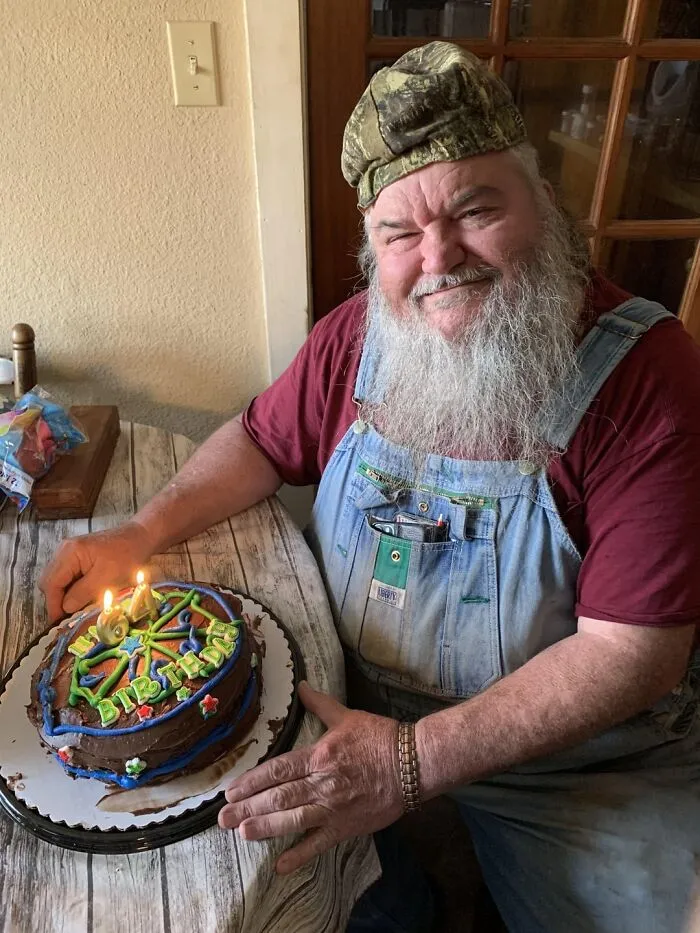Hombre mayor sonriente con pastel de cumpleaños, imagen reconfortante para distraerse de los horrores actuales del mundo