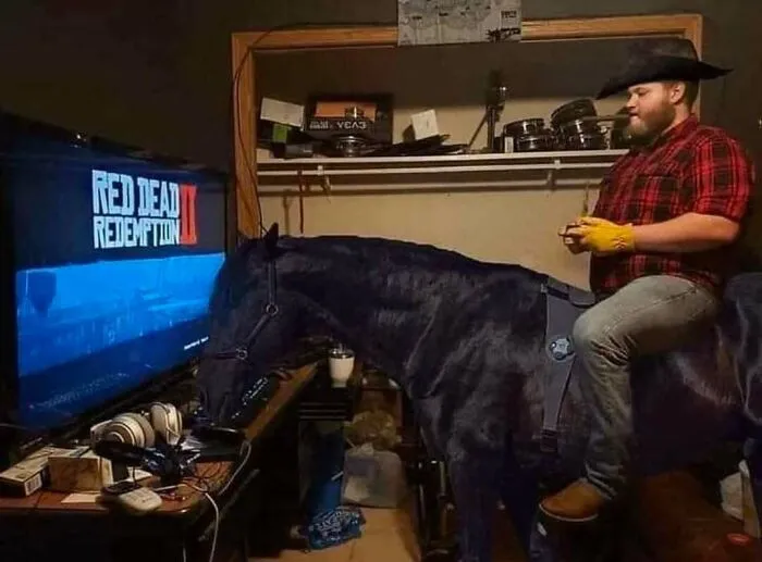 Man wearing a cowboy hat and gloves riding a realistic horse indoors while playing a video game, nerdy memes concept.