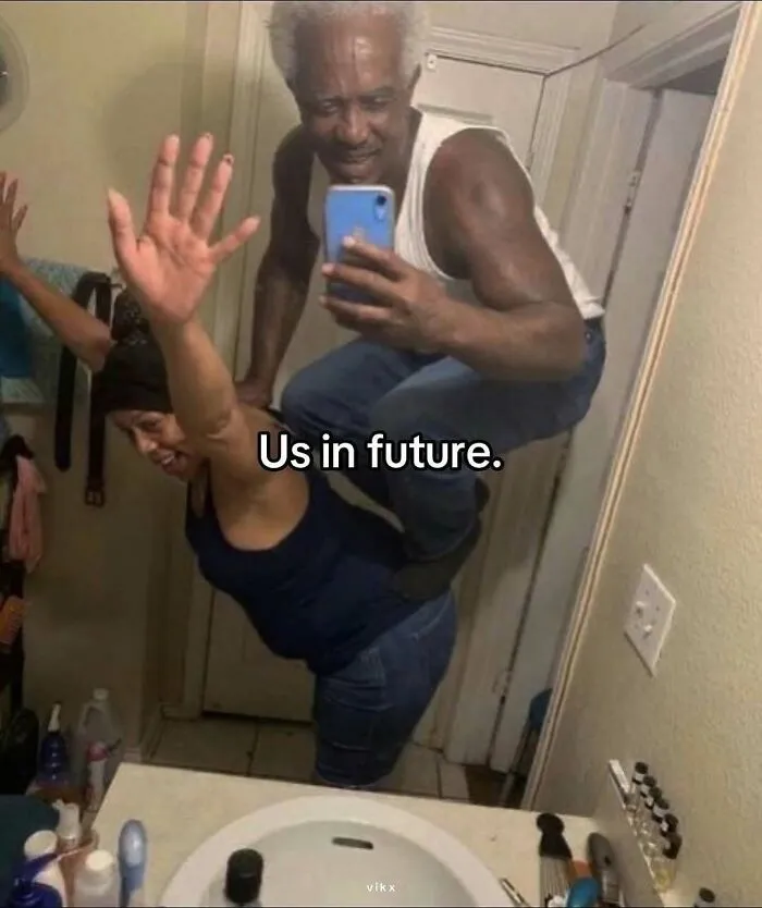 Two people posing humorously in a bathroom mirror, creating one of the pics that make no sense at all.