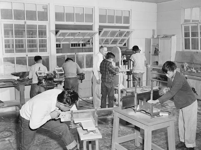Students working with woodworking tools in a classroom showing schools worldwide during World War II activities.