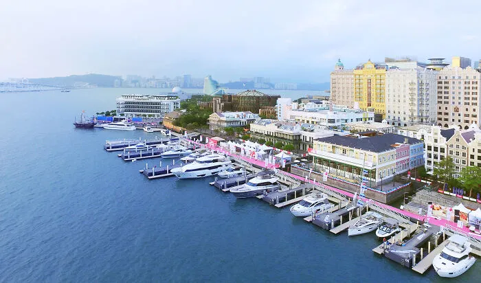 Aerial view of luxury yachts docked at a marina alongside colorful buildings in one of the smartest countries shaping the future.