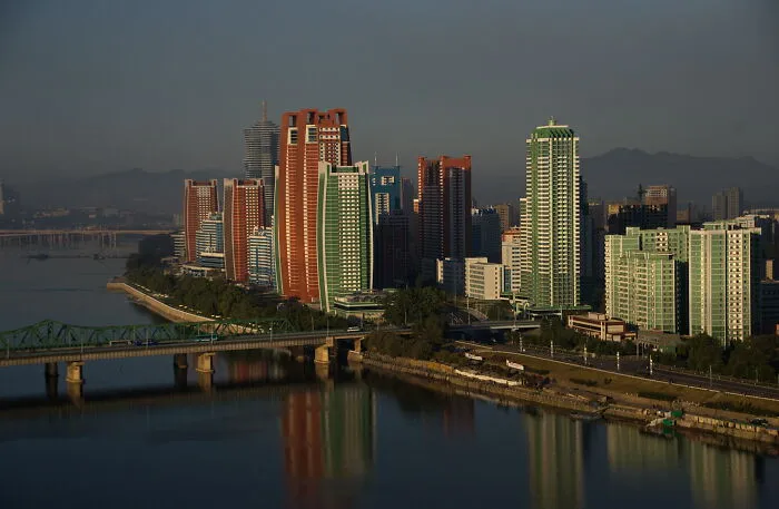 City skyline with modern high-rise buildings reflected on river, representing smartest countries shaping the future of the world.