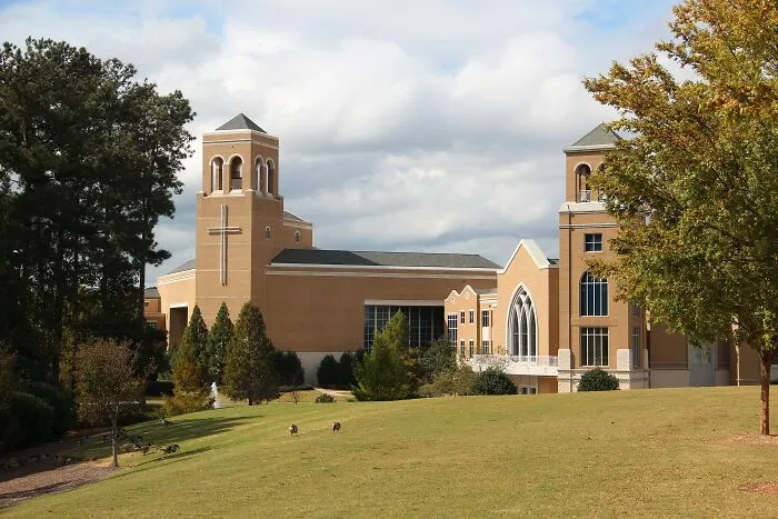 Modern church building with a cross on the tower, surrounded by trees and green lawn, showcasing best places to live in the USA.