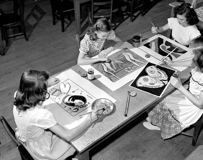 Girls painting artistic images at a school art class during World War II, showcasing schools worldwide during the war era.