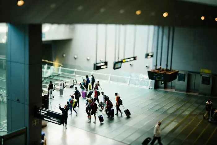 Travelers with luggage walking through a modern U.S. airport terminal sharing surprising things about travel experiences.