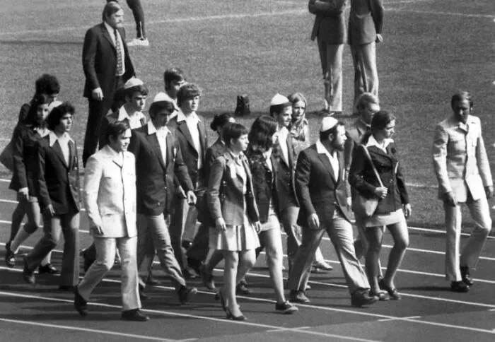 Group of people walking on a track in formal attire in a black and white photo with a terrifying and horrific backstory.