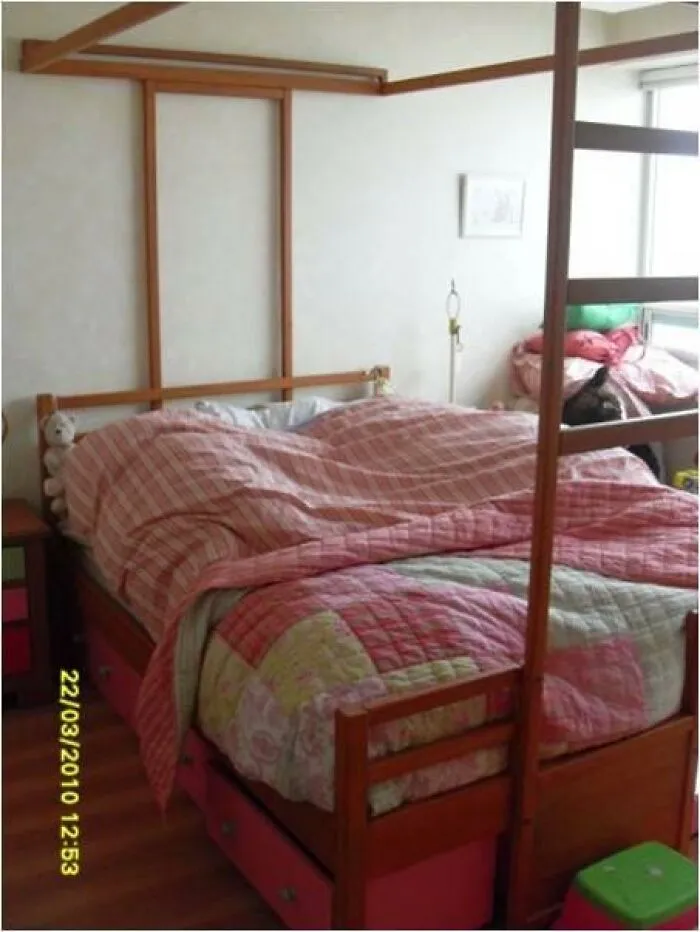 Bed with pink plaid bedding and stuffed animals in a room, linked to terrifying and horrific backstories photos.