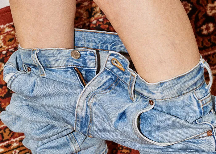 Piernas de paciente con pantalones abajo sobre alfombra, ilustrando casos médicos que requirieron atención urgente.