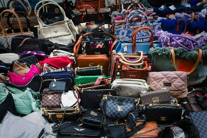Various designer handbags displayed together, illustrating trends leading to overconsumption and consumer excess.
