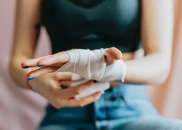 Person wrapping hand with medical bandage, highlighting doctors' warnings about death machines and health risks.