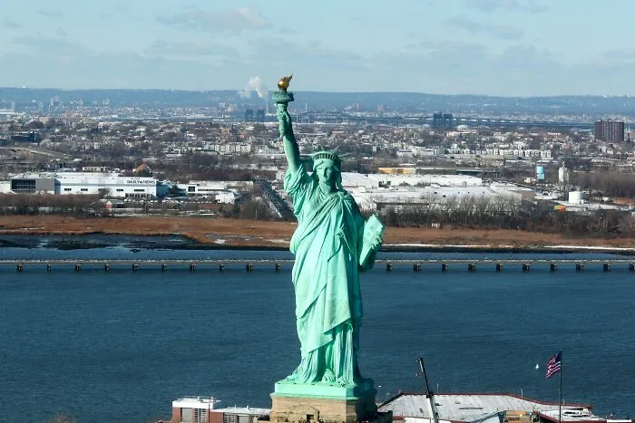 Statue of Liberty standing tall near water with cityscape in the background, illustrating rare phobias related to heights and space.