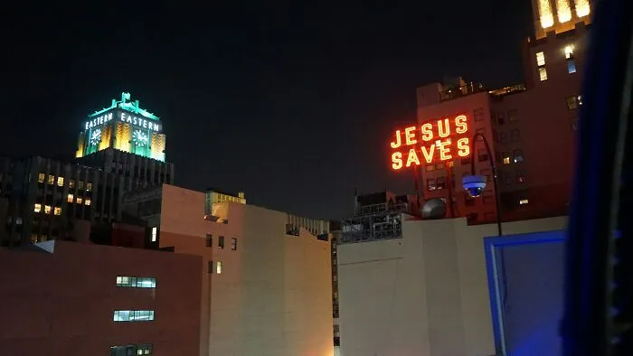 City skyline at night featuring iconic neon signs, highlighting surprising things travelers discover about the U.S. when they visit.