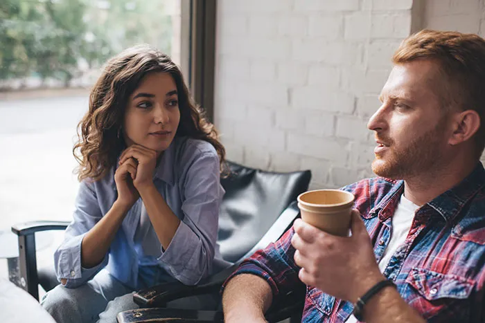A man and woman having a serious conversation, illustrating single male behaviors that destroy hope for romance.