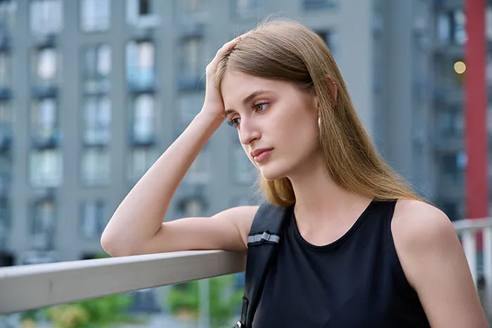 Young woman looking thoughtful and concerned outdoors, reflecting on single male behaviors that destroy romance.