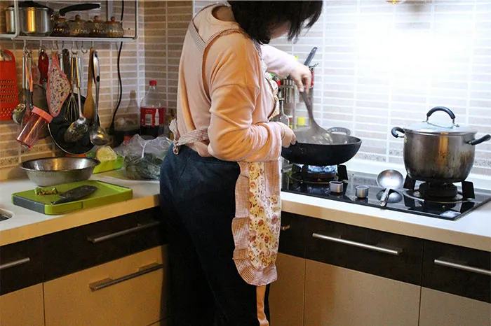 Person cooking in a kitchen sharing cooking secrets and ingredients while stirring food on a stovetop burner.