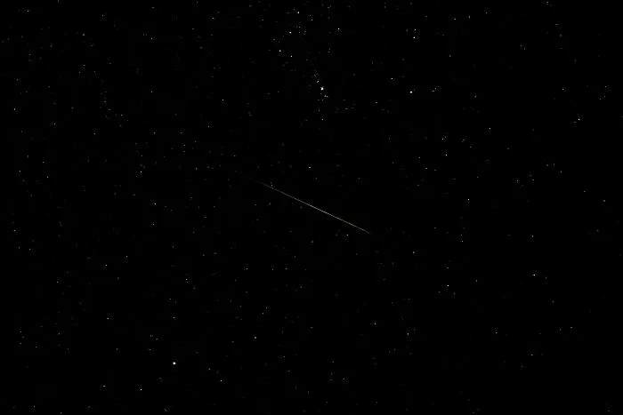 Night sky filled with stars and a faint shooting star, illustrating one of the most interesting mysteries that still baffle people.