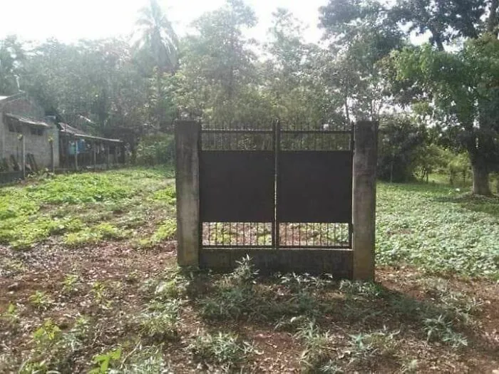 A gate installed in the middle of a field without any fencing, highlighting engineering mistakes in design.