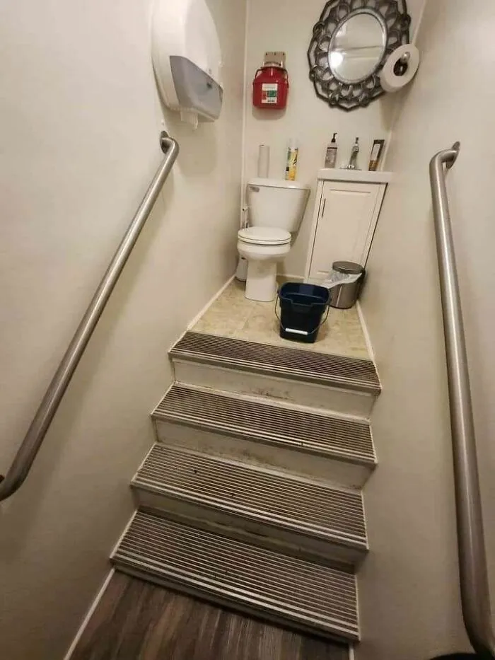 Stairs leading directly to a toilet with handrails, illustrating hilariously dumb engineering mistakes in design.