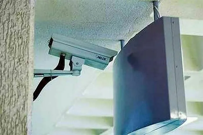 Security camera mounted directly behind a large TV screen, illustrating engineering mistakes despite degrees.