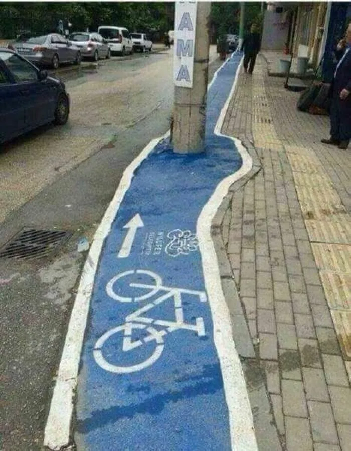 Bike lane with a utility pole in the middle, showcasing one of the hilariously dumb engineering mistakes on a city street.