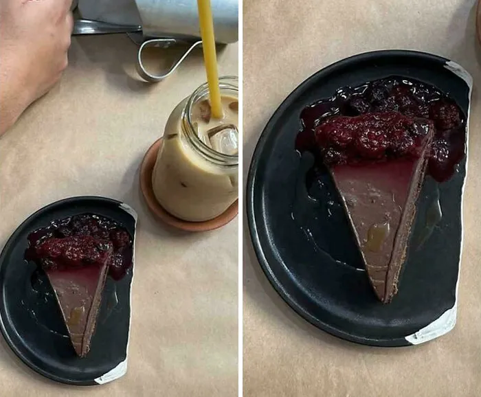 Partially broken black plate with a slice of chocolate dessert and berry sauce served in an unholy way next to an iced drink.