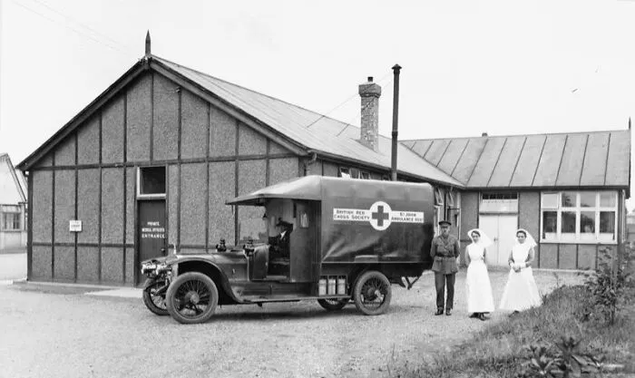 Nurses And A Medical Officer Standing By A Red Cross And St John's Ambulance Association Ambulance And Its Driver, In A Compound For Medical Officers