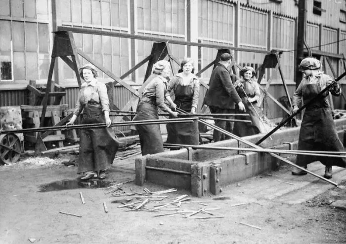 Female Workers Carrying Metal Rods In A Naval Ship Building Yard