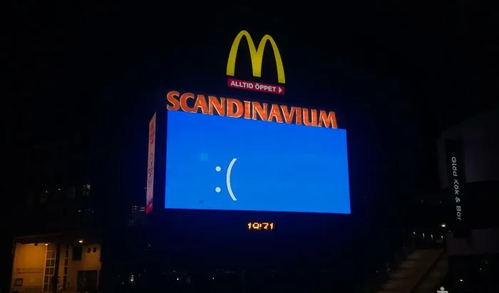 Publicidad con fallo digital mostrado en pantalla azul con emoticón triste junto a logotipo de McDonald's.