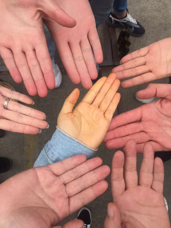 Manos humanas extendidas en círculo mostrando rasgos distintivos del cuerpo humano que hacen destacar a la gente.