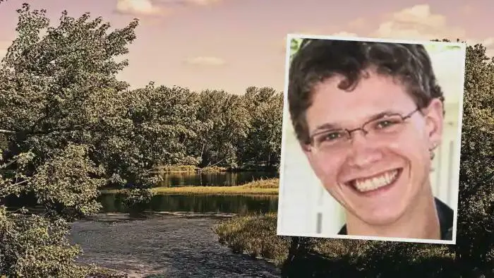 Smiling person wearing glasses over a scenic river landscape with trees under a cloudy sky, highlighting interesting content.