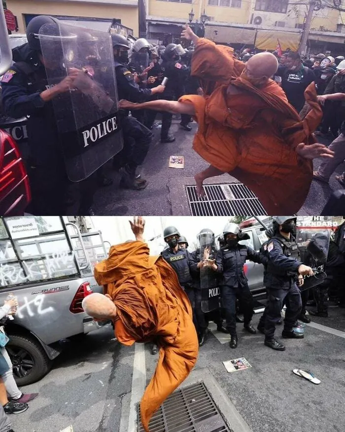 Monk in orange robe performing martial arts move in front of police officers during street protest, interesting moment from online community.